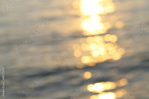 Abstract golden sunlight bokeh on blue sea water background.