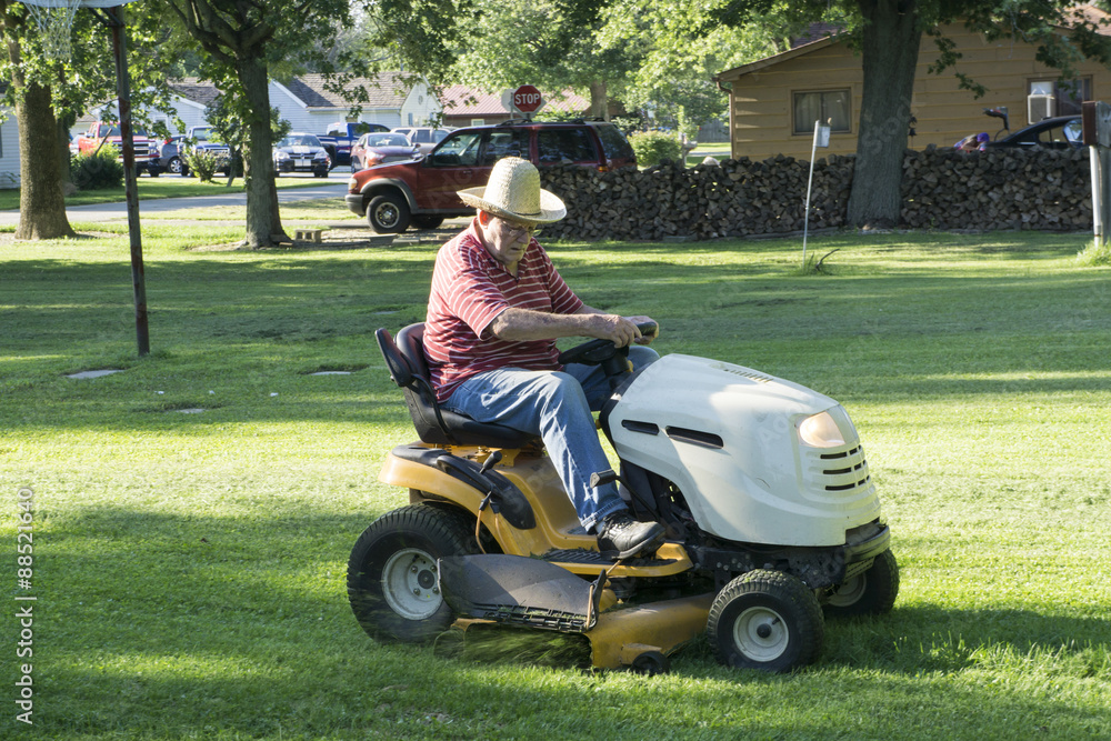 Senior Citizen Cutting Grass With A Straw Hat On Senior Citizen Cutting Grass With A Straw Hat On