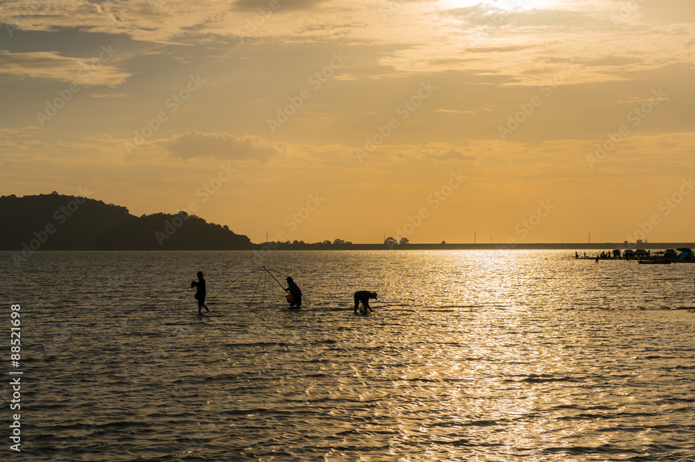 silhouette of fisherman in sunset 
