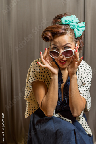 Pretty female wearing sunshades and retro style