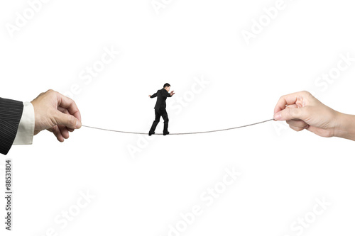 Fotografie Businessman balancing on tightrope with man and woman hands hold