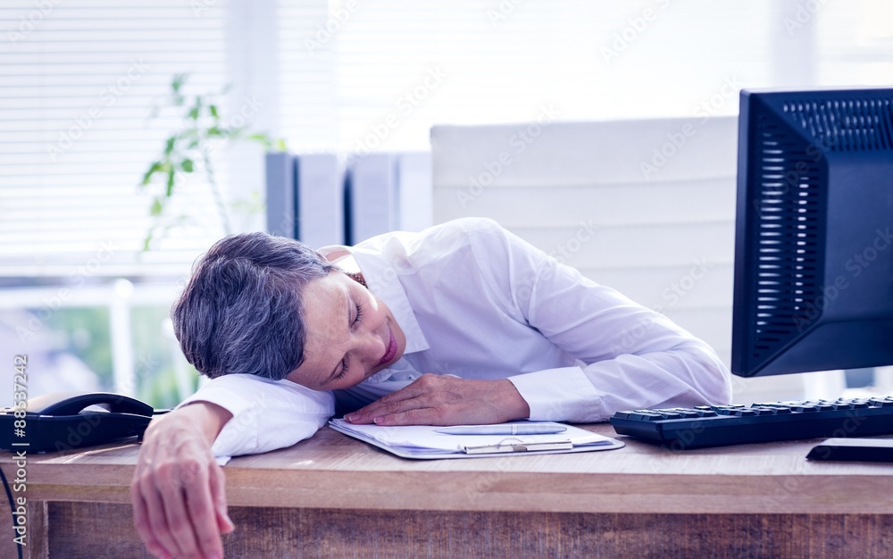 Tired businesswoman sleeping at her desk Tired businesswoman sleeping at her desk