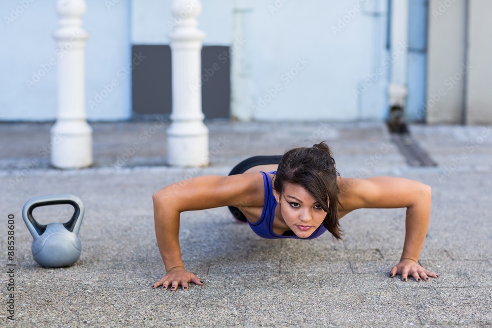 Fototapeta premium Focused athletic woman doing push-ups 