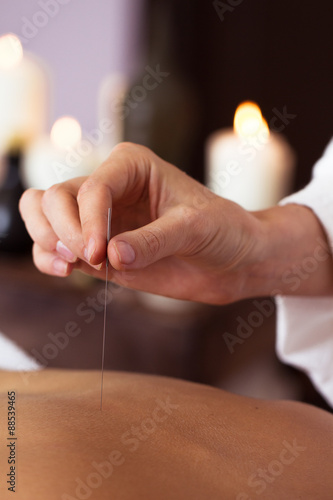 Beautiful young woman relaxing with hand massage at beauty spa.