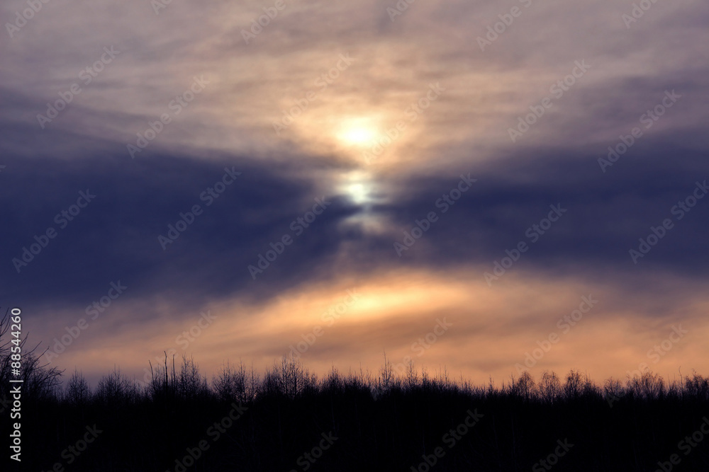 Winter sunset over forest with clouds on evening sky Winter sunset over forest with clouds on evening sky