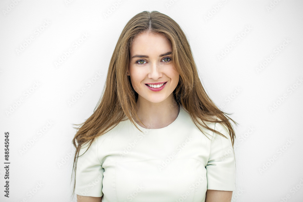 Beautiful young happy woman posing against a white wall Beautiful young happy woman posing against a white wall