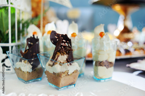chocolate desserts in parfait cups on a white table, decor with