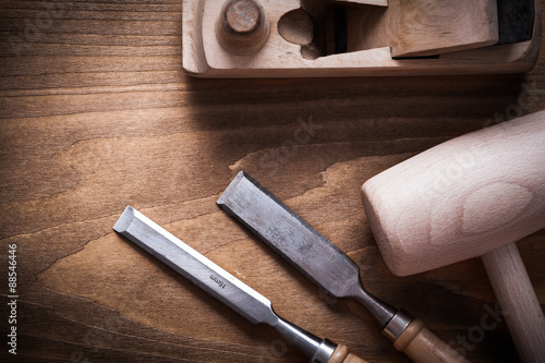 фотографія Wooden mallet shaving plane firmer chisels on wood board constru