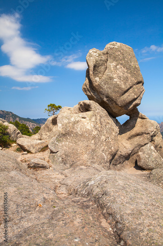 Big round stone lays on top of a mountain © evannovostro