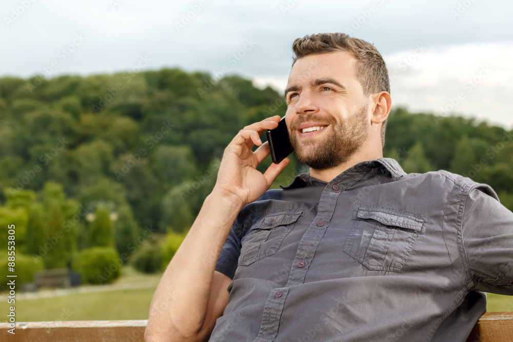 Relaxed man in park talking on mobile phone Relaxed man in park talking on mobile phone