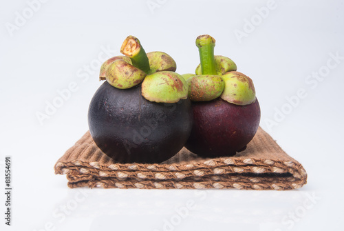 Mangosteen fruit and cross section showing the thick purple skin