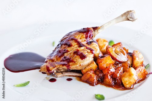 chicken with vegetables on white plate served topped with berry sauce