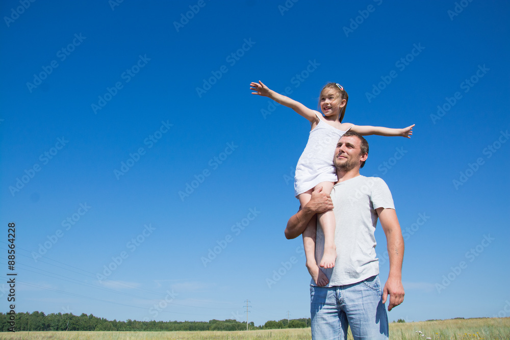 Happy father with his little daughter in his arms in the field Happy father with his little daughter in his arms in the field