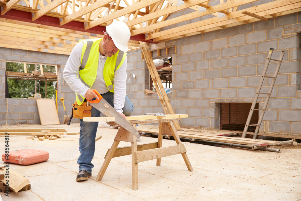Carpenter Cutting House Roof Supports On Building Site Carpenter Cutting House Roof Supports On Building Site