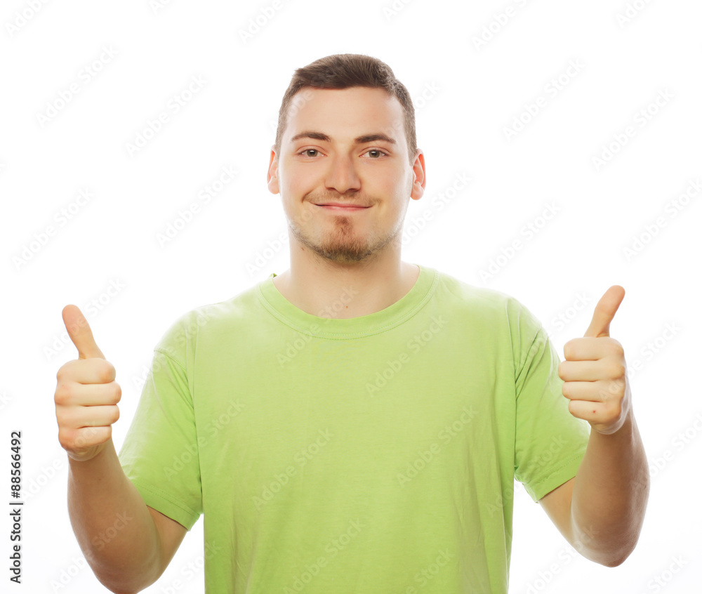 young man in green shirt showing thumbs up. young man in green shirt showing thumbs up.