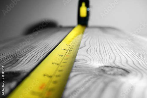 Tape measure wood.
Abstract image of a tape measure on a piece of wood. photo