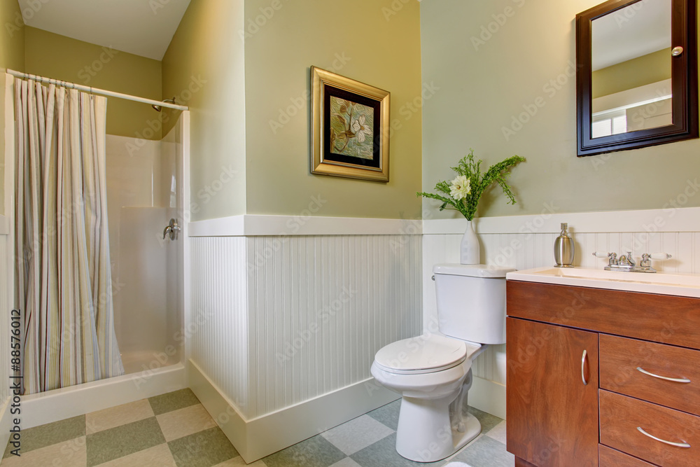 Bathroom with checkered tile floor, and green white walls. Bathroom with checkered tile floor, and green white walls.