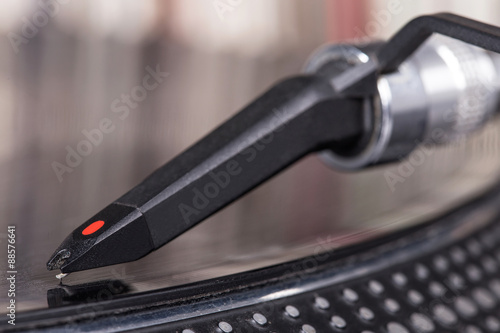 Dj stylus on spinning vinyl, record background