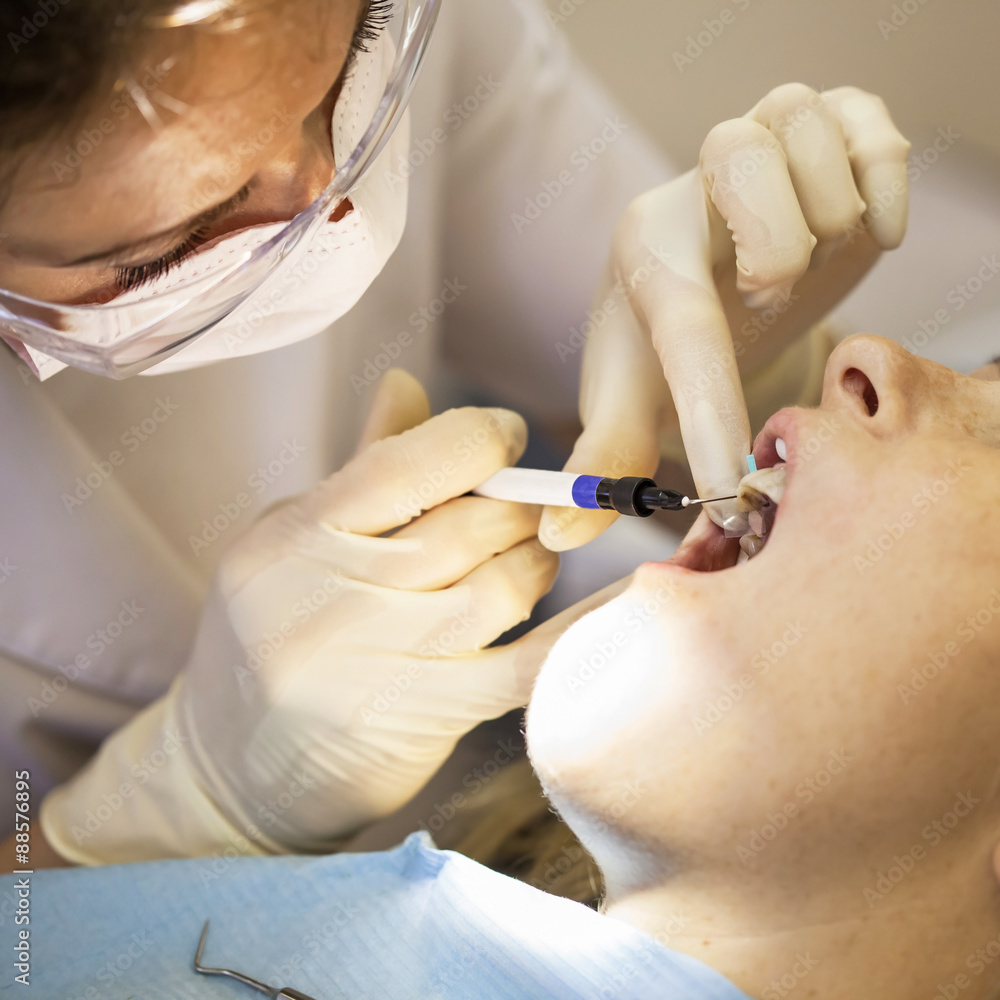 Dentist curing a female patient Dentist curing a female patient