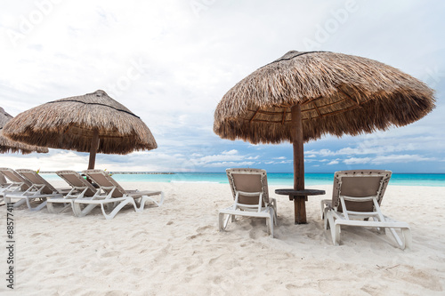 Sun umbrellas and chairs on caribbean beach © photopixel