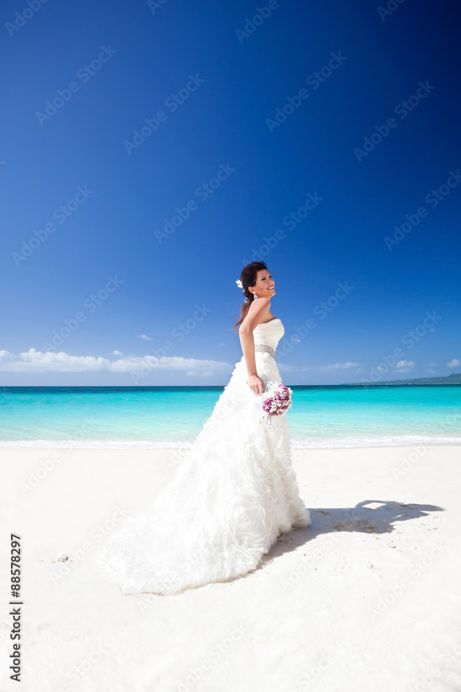 Beautiful bride on white sandy beach, smiling and feeling happin Beautiful bride on white sandy beach, smiling and feeling happin
