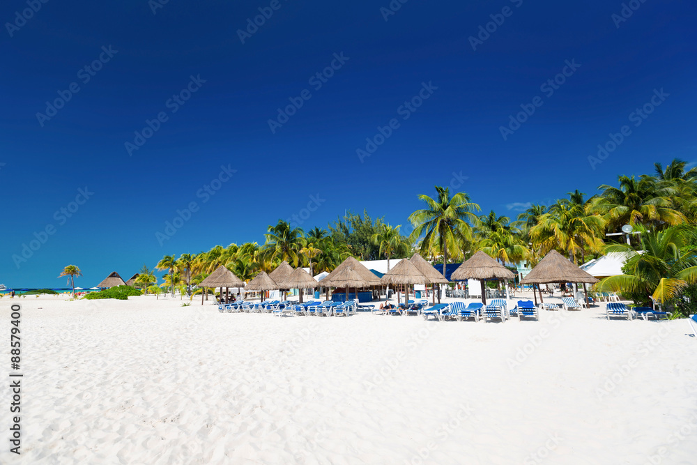 Fototapeta Karaibska plaża z parasolami i łóżkiem