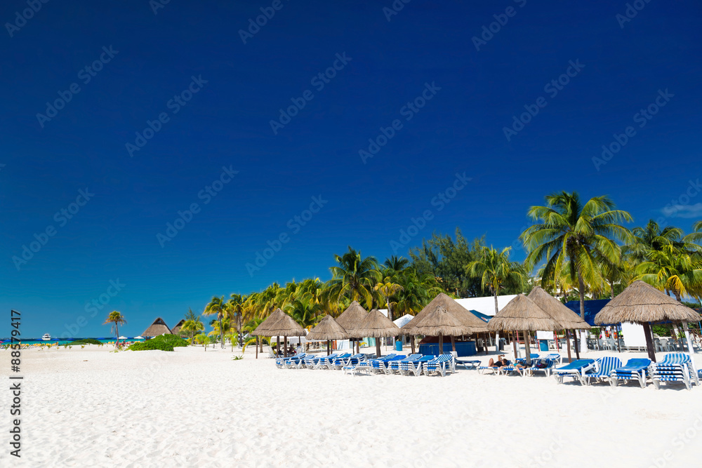 Caribbean beach with sun umbrellas and bed