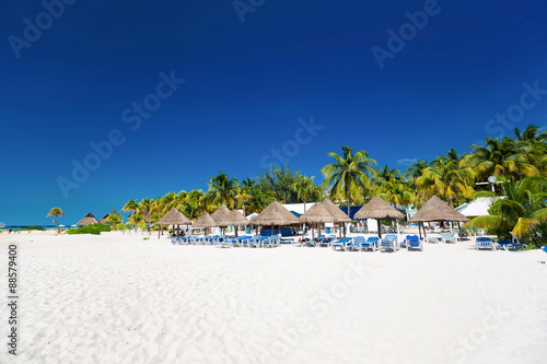 Caribbean beach with sun umbrellas and bed