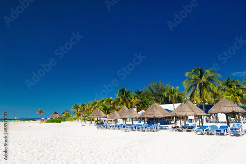 Caribbean beach with sun umbrellas and bed