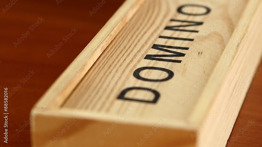 Domino game in closed box, isolated on wooden surface, slow Domino game in closed box, isolated on wooden surface, slow