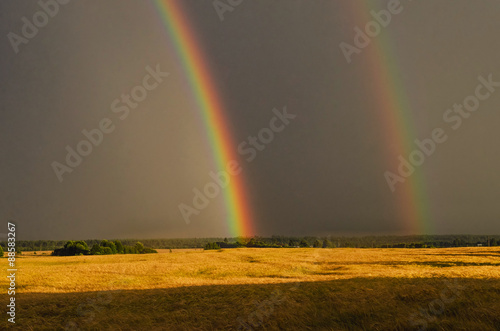 Primary and secondary rainbow over land. Russian nature