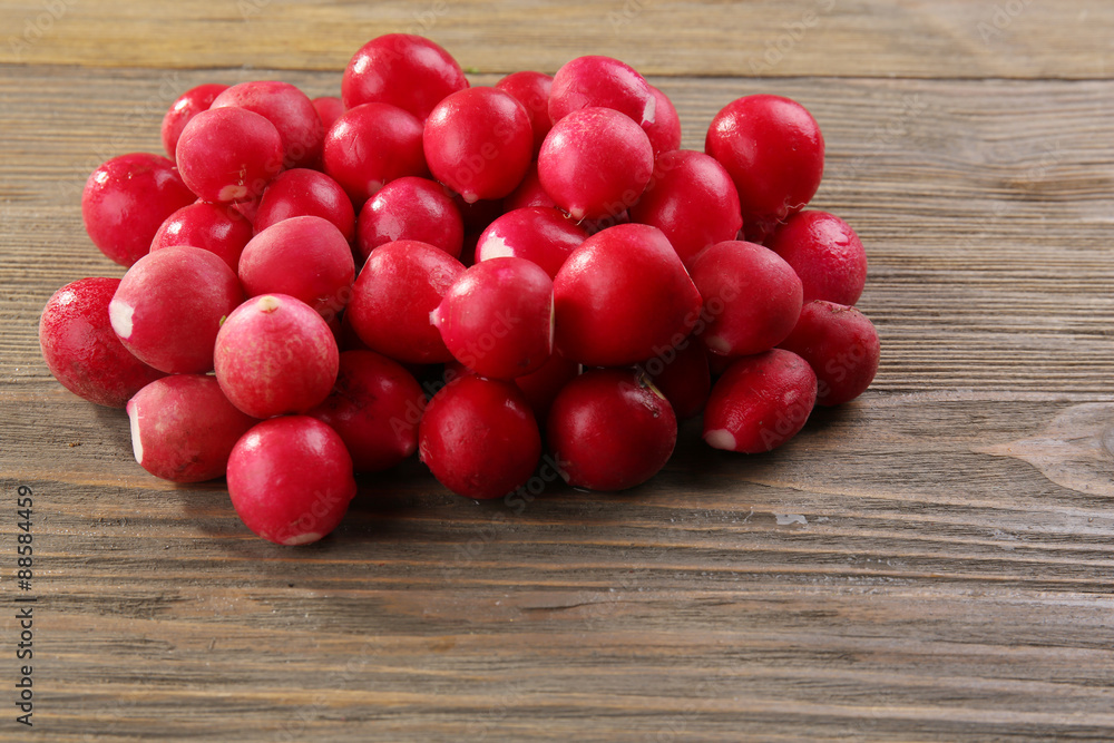 Heap of fresh radishes on wooden table close up background Heap of fresh radishes on wooden table close up background