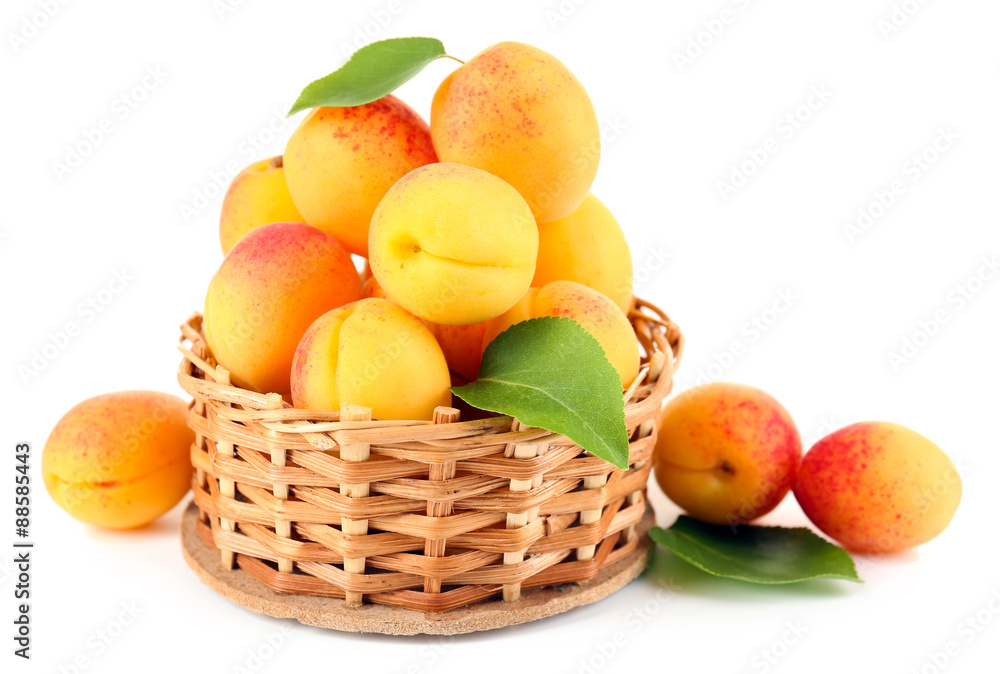 Ripe apricots in wicker bowl isolated on white Ripe apricots in wicker bowl isolated on white