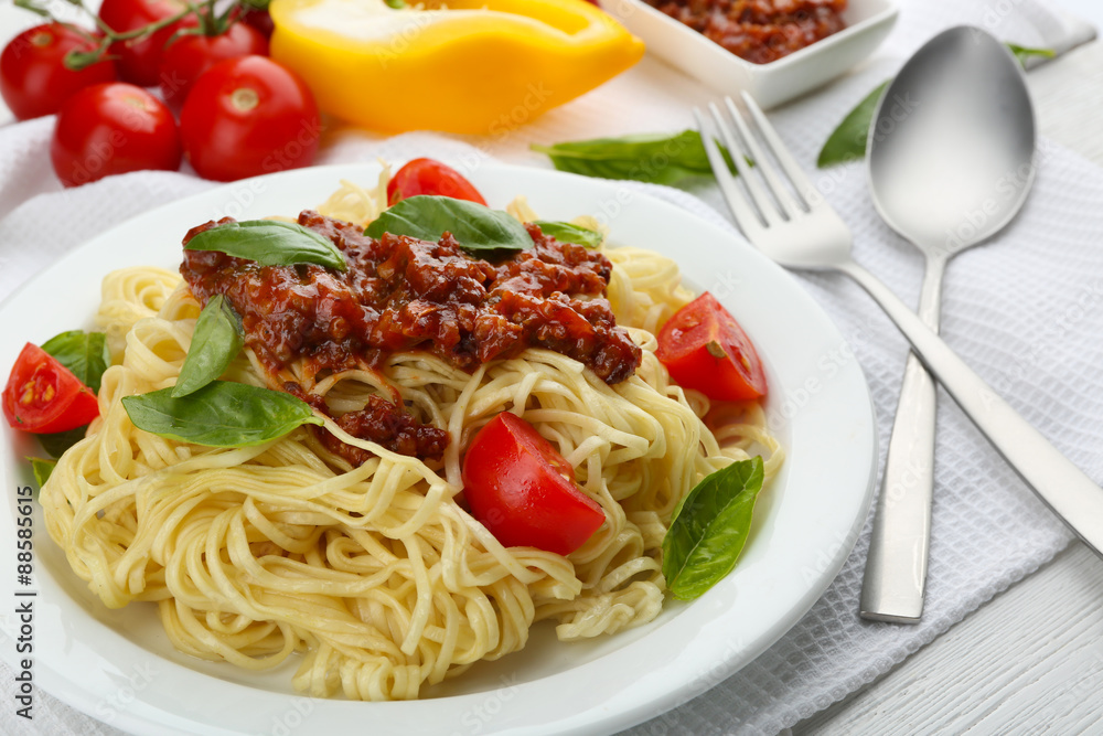 Spaghetti Bolognese on white plate, on color wooden background Spaghetti Bolognese on white plate, on color wooden background