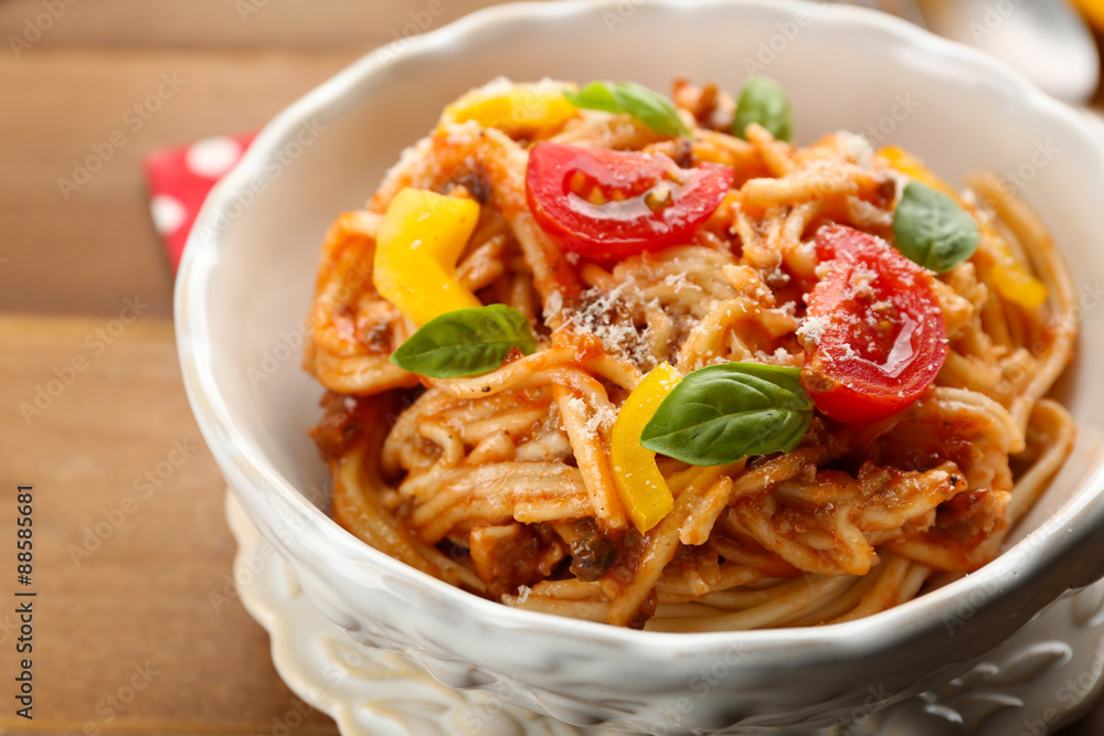 Homemade Spaghetti Bolognese with parmesan cheese in white bowl, on color wooden background Homemade Spaghetti Bolognese with parmesan cheese in white bowl, on color wooden background