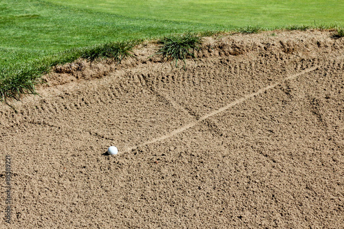 Photography Golf ball rolling into a sand trap with track