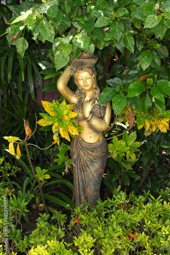 woman statue and ornamental plant in garden