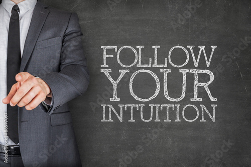 Follow your intuition on blackboard with businessman photo