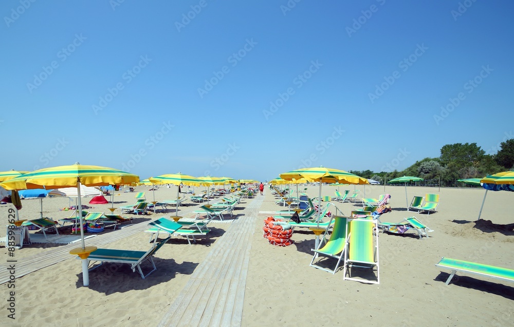 sunbeds with umbrellas in sunny beach in summer