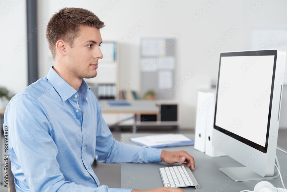 kaufmann im büro schaut auf computer kaufmann im büro schaut auf computer