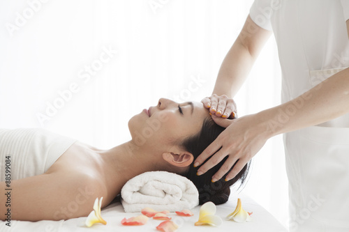 Beautiful Asian woman receiving head massage