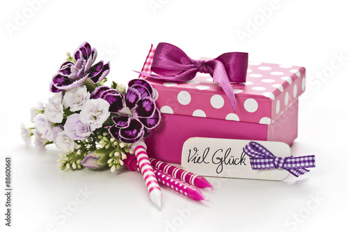 Geschenk mit Kerzen und Blumen auf weißem Hintergrund