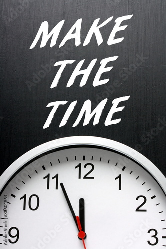 The phrase Make The Time in white text on a blackboard above a modern wall clock with the hands pointing at twelve midnight