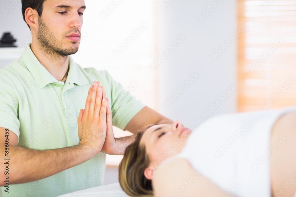 Relaxed pregnant woman getting reiki treatment