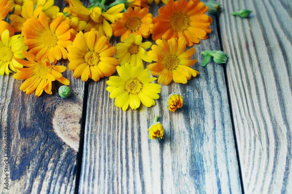 Yellow summer flowers on a wooden surface. Bouquet from a marigold. Calendula flowers. Holidays background  in vintage style.