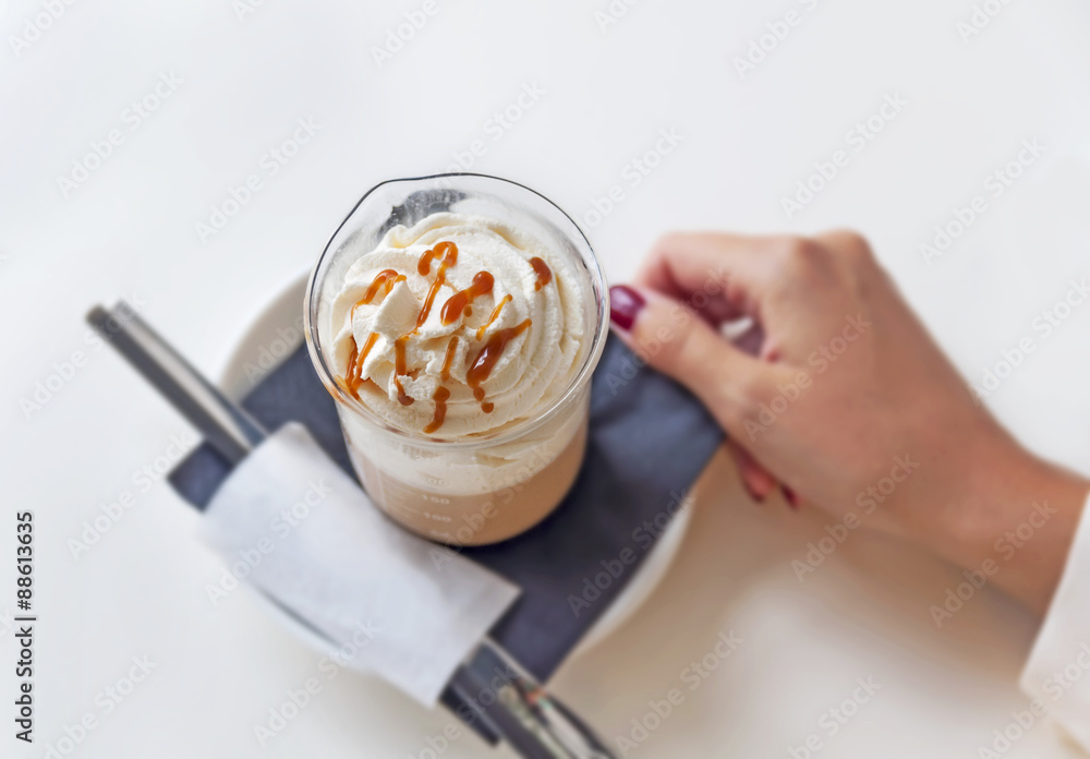 Cup of a fresh caramel latte with whipped cream on table in coff Cup of a fresh caramel latte with whipped cream on table in coff