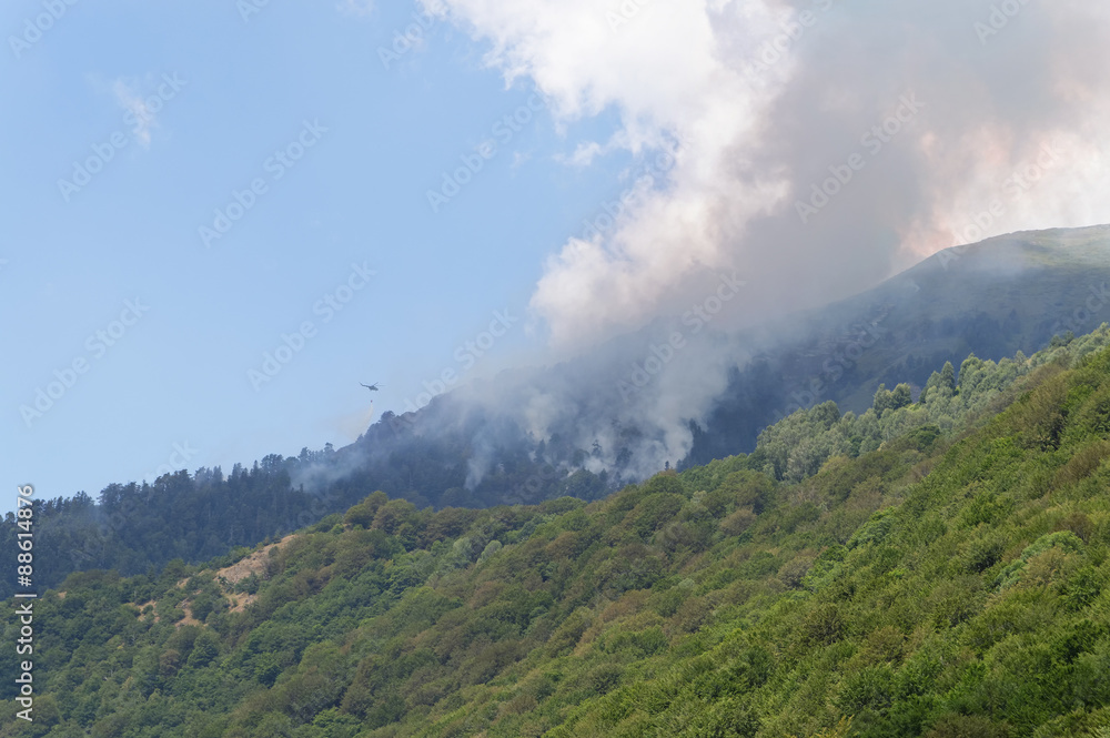 Helicopter fighting wild mountain fire