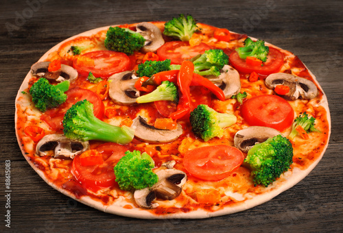Vegetarian pizza on a wooden table.
