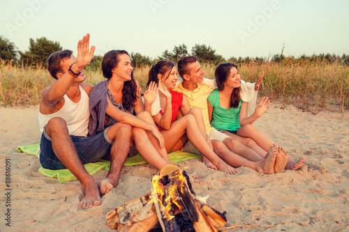 smiling friends in sunglasses on summer beach