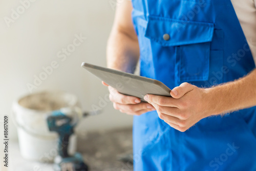 close up of builder or workman with tablet pc